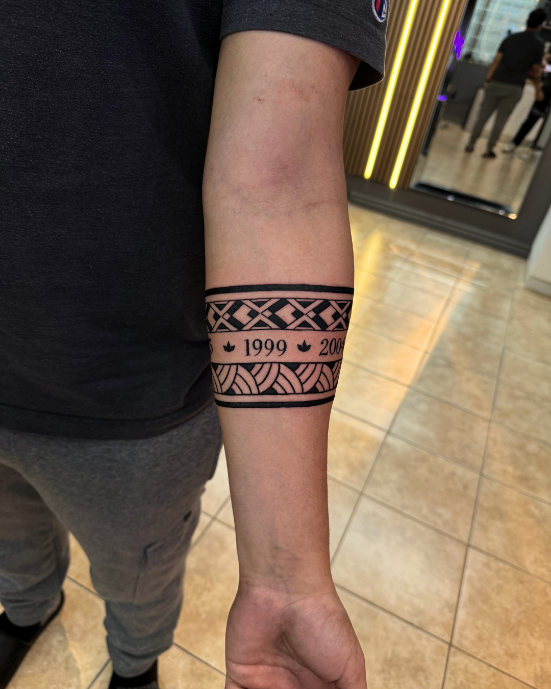 Polynesian style tribal armband tattoo with numbers 1999 and 2004