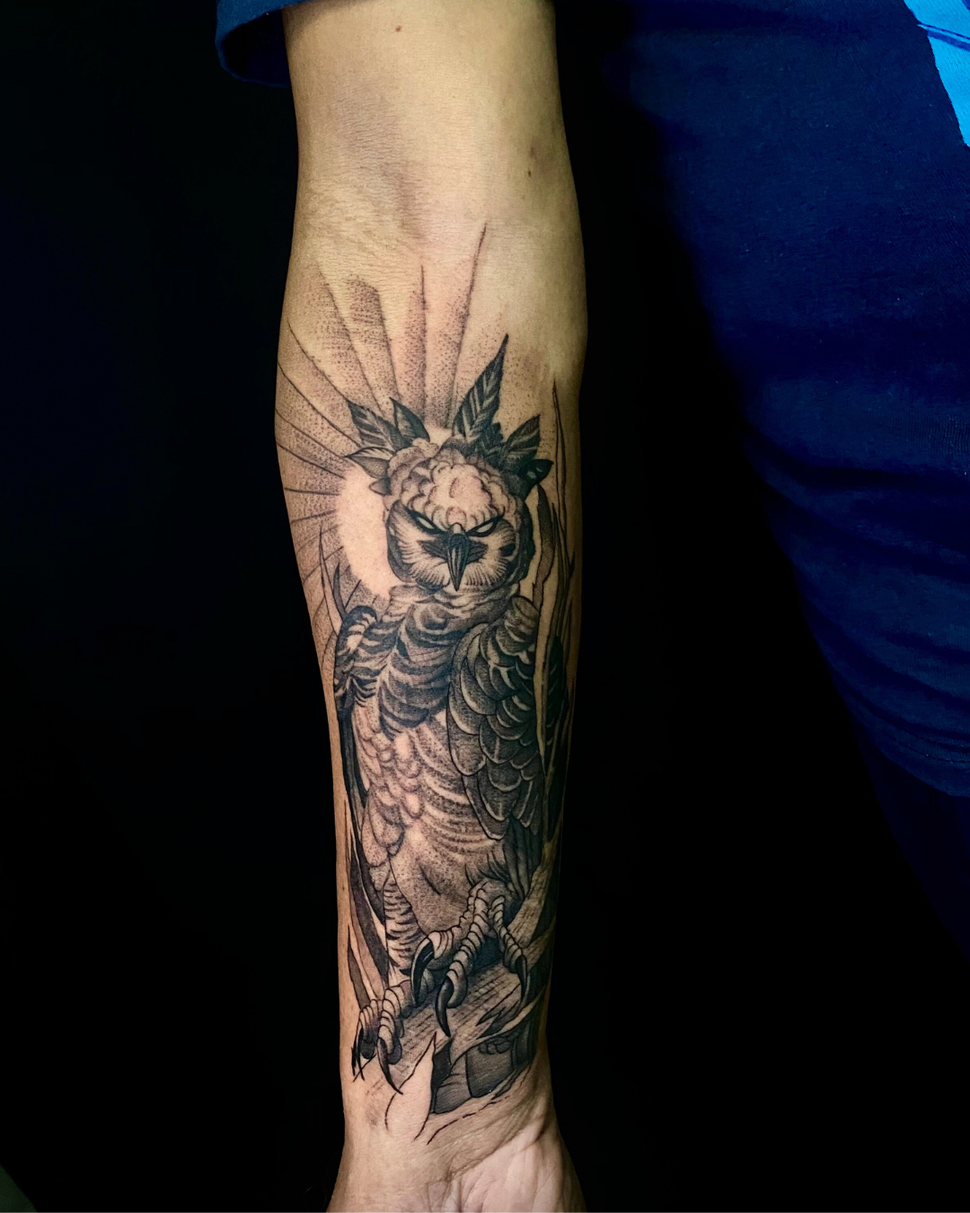 Black and grey forearm tattoo of a woman wearing a lion headdress