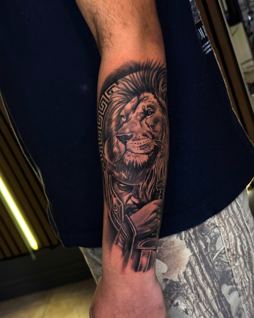 Intricate black and grey Mayan or Aztec calendar and mask on the upper arm