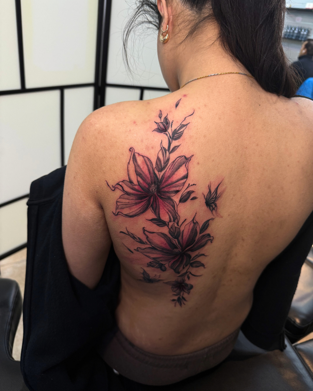 Black and grey chest tattoo featuring a large compass and two swallows