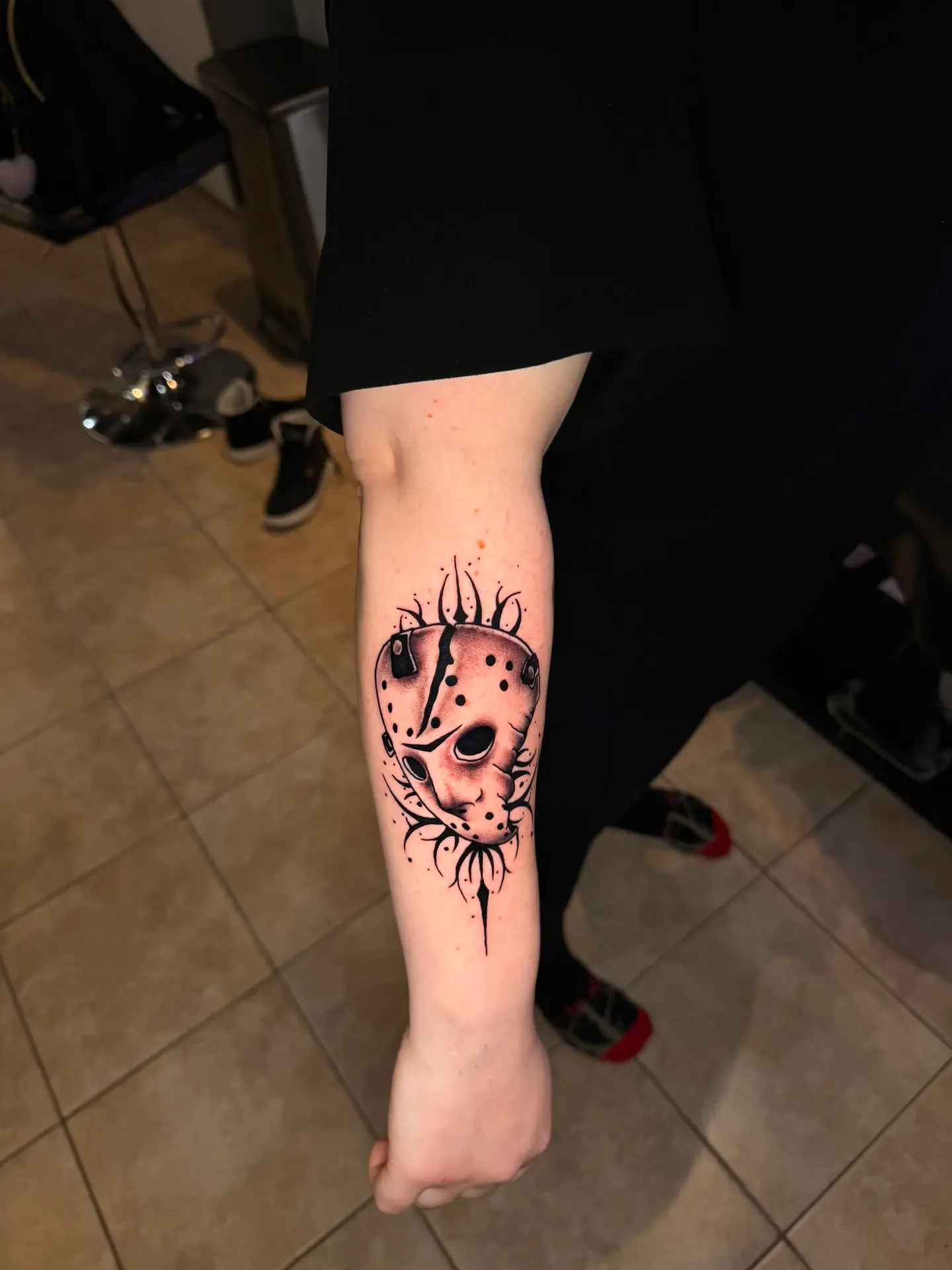 Black and grey horror mask tattoo framed with sharp cyber-sigilism accents