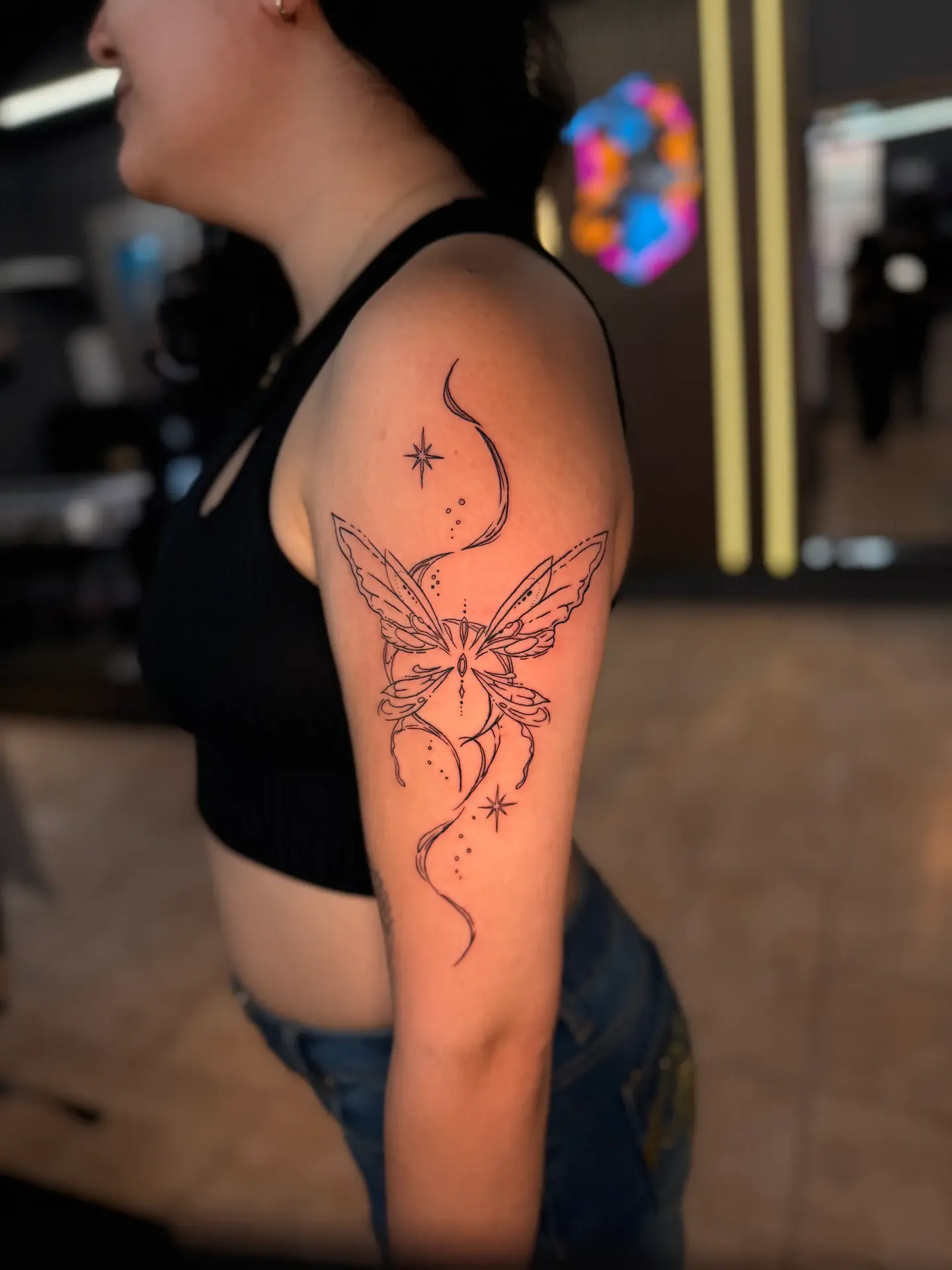 Ethereal cyber-fairy butterfly wing tattoo on upper arm