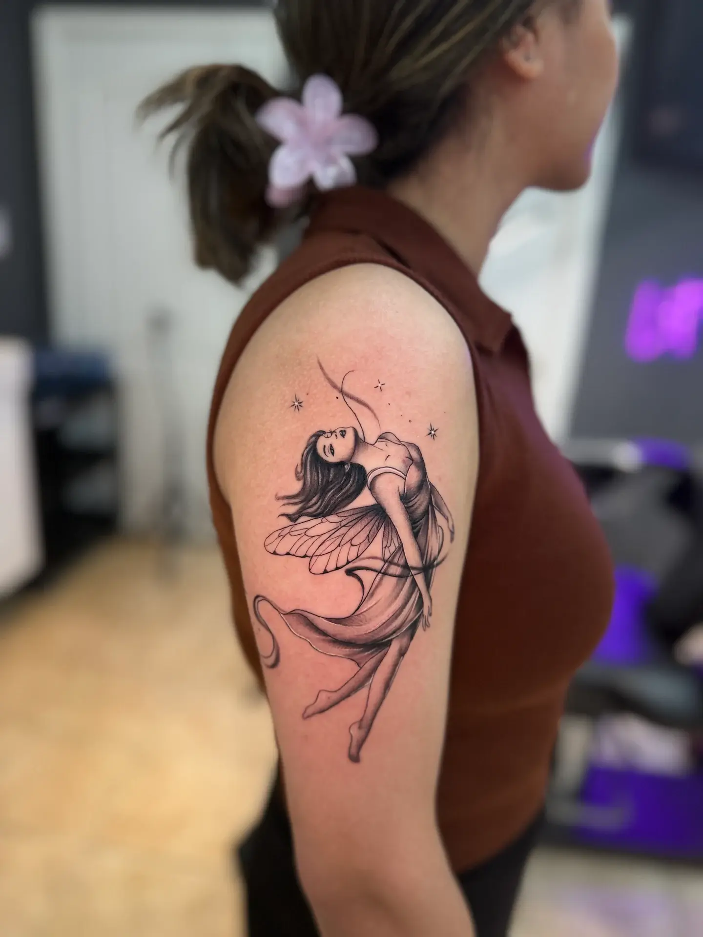 Fine line tattoo of an ethereal fairy on upper arm