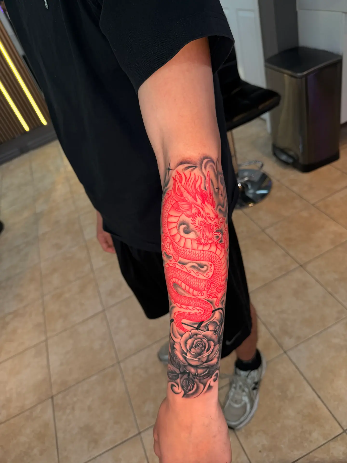 Dual-tone crimson red dragon intertwined with black rose tattoo