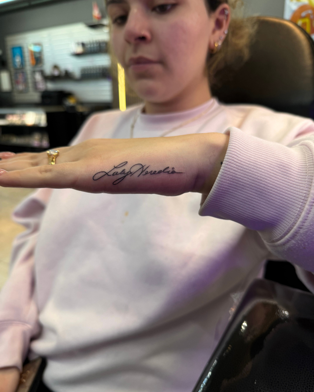 Fine line cursive script name on the side of the hand