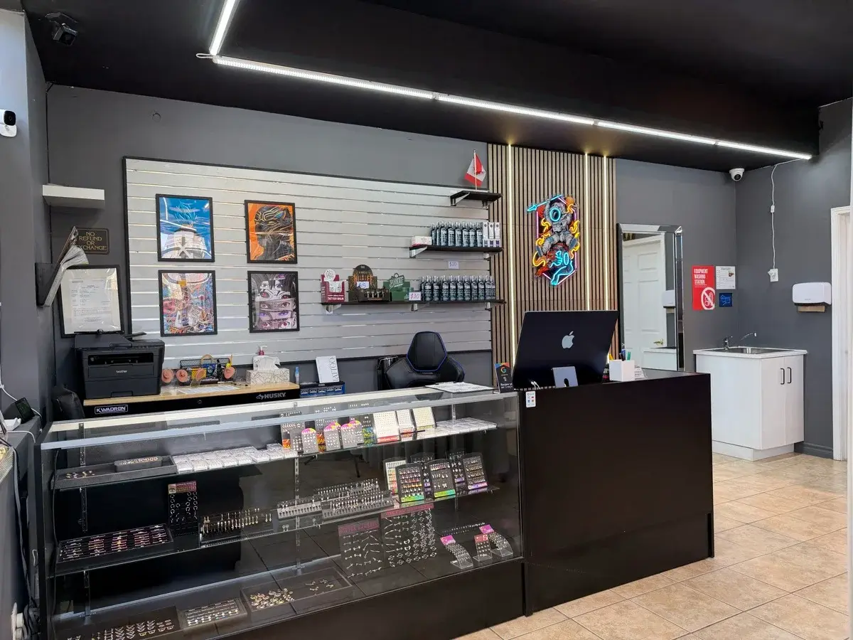 Front reception area of Ink Me Toronto with jewelry display counter and custom artwork