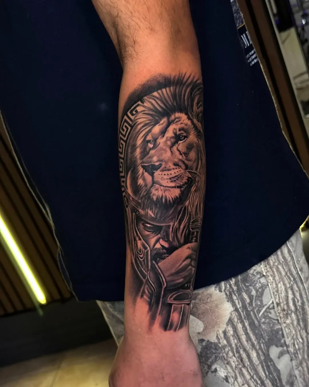 Intricate black and grey Mayan or Aztec calendar and mask on the upper arm