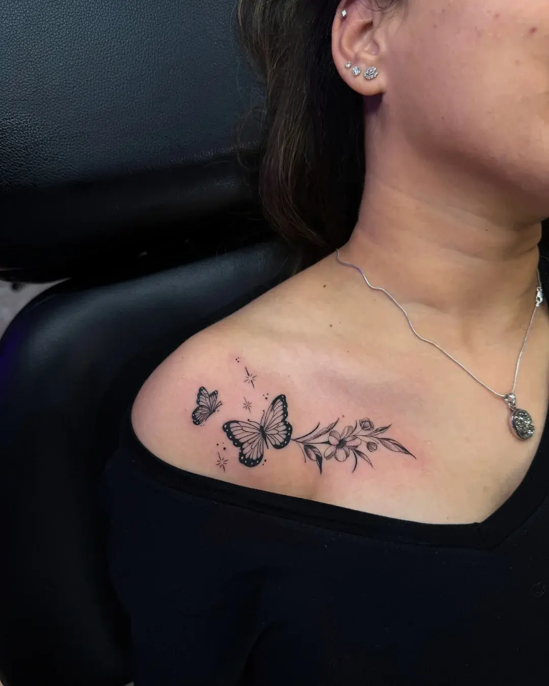 Fine line cherry blossom floral tattoo on collarbone